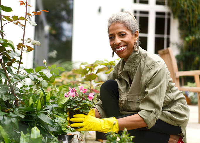 A African American woman smiling while gardening outside